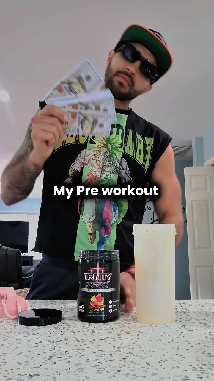 Xavier holding up a tub of Trinity pre-workout and a shaker
